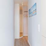 Flur mit Kleiderschrank und Wandbild an der Wand.