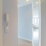 Eingangsbereich mit Glaswand und Blick in Wohnbereich mit Tisch und Stühlen.