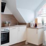 Küche mit Arbeitsplatte, Spüle, Herd und Fenster mit Blick.