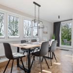 Dining room with table, chairs, and windows to the garden.