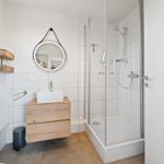 Bathroom with shower, sink, and mirror