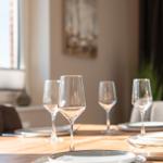 Dining table with glasses and plates in dining room