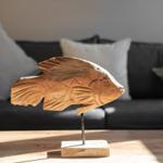 Wooden fish sculpture on table in front of sofa with cushions