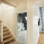 Treppenhaus mit Bad und Schlafzimmer mit blumigem Tapetenmuster