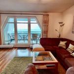 Wohnzimmer mit Sofa, Couchtisch und Balkon mit Meerblick.