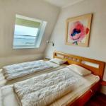 Schlafzimmer mit Doppelbett, Fenster und Wandbild.