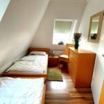 Zimmer mit zwei Betten, Schrank und Fenster unter Dachschrägen.