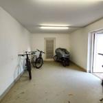 Garage mit mehreren Fahrrädern und einer Tür zum Außenbereich.