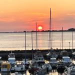 Sonnenuntergang über Hafen mit Booten und Wasser