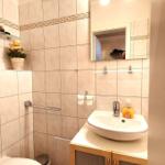 Badezimmer mit Waschbecken, Spiegel, Toilette und Handtuchhalter.