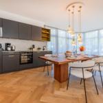 Küche mit Essbereich, Holzboden und großem Fenster