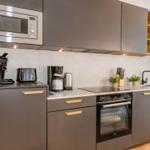 Küche mit Dunstabzug, Herd, Kühlschrank und Arbeitsplatte.