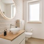 Badezimmer mit Waschtisch, Spiegel und Toilette