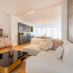 Wohn- und Essbereich mit moderner Küche und großem Sofa.