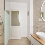 Badezimmer mit Dusche, Waschbecken und Spiegel