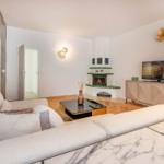 Wohnzimmer mit Sofa, Kamin und Fernseher.