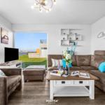 Wohnzimmer mit Sofa, Couchtisch und Blick auf Terrasse