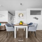 Wohn- und Essbereich mit Sofa, Esstisch und Küche.