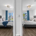 Zwei Schlafzimmer mit Blick auf den Balkon und blaue Vorhänge.