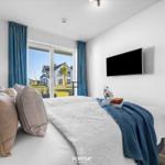 Schlafzimmer mit Bett, TV und Blick auf Garten