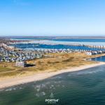 Ausblick auf Küstenort mit Häusern, Hafen und Meer