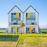 Zweistöckiges Haus mit Balkonen und Blick auf Wasser