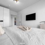 Schlafzimmer mit Bett, TV und Kleiderschrank