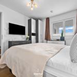 Schlafzimmer mit Bett, Fernseher und Fenster mit Blick.