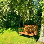 Holzschaukel unter Bäumen im Garten