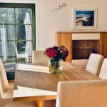 Esstisch mit sechs Stühlen und Blumen im Esszimmer. Durchgang zur Terrasse.