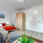 Schlafzimmer mit Bett, Kleiderschrank und Fernseher.