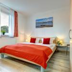 Schlafzimmer mit Bett, Fenster und Kleiderschrank