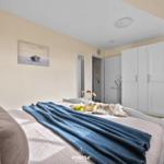 Schlafzimmer mit Bett, Kleiderschrank und Wandbild