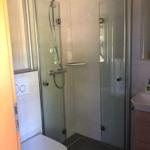 Badezimmer mit Dusche, Toilette und Waschbecken.