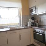 Küche mit Fenster, Spüle, Herd und Mikrowelle.