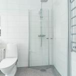 Badezimmer mit Dusche, Toilette und Waschbecken.