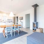 Küche, Essbereich und Wohnbereich mit Holztisch, Stühlen und Kaminofen.