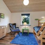 Bedroom with wooden floor, bunk bed, and blue rug.