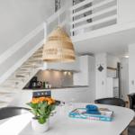 Küche mit Essbereich, Treppenhaus und Wohnzimmer im Hintergrund.