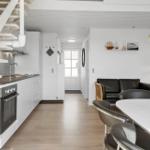 Küche mit Essbereich und Wohnzimmer mit Treppenhaus