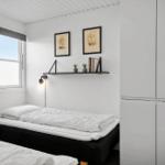 Zimmer mit Bett, Fenster, Wandregal und Kleiderschrank.