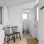 Zimmer mit zwei Stühlen, Fenster und Tür zum Bad.
