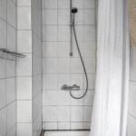 Dusche mit Duschbrause und Duschvorhang