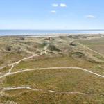 Weitläufige Dünenlandschaft mit Wanderwegen und Blick auf die Nordsee.