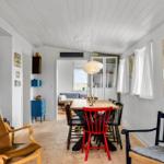 Esszimmer mit Holztisch, rotem Stuhl und brauner Ledercouch