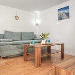 Ein Wohnzimmer mit grauem Sofa, Holztisch und Wandbild.