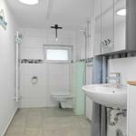 Badezimmer mit Dusche, WC und Waschbecken.