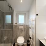 Badezimmer mit Dusche, Toilette und Waschbecken