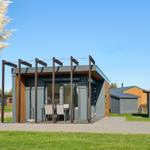 Moderne Unterkunft mit Terrasse und Garten. Sicht auf angrenzende Häuser.