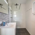 Badezimmer mit Dusche, Waschbecken und Fenster